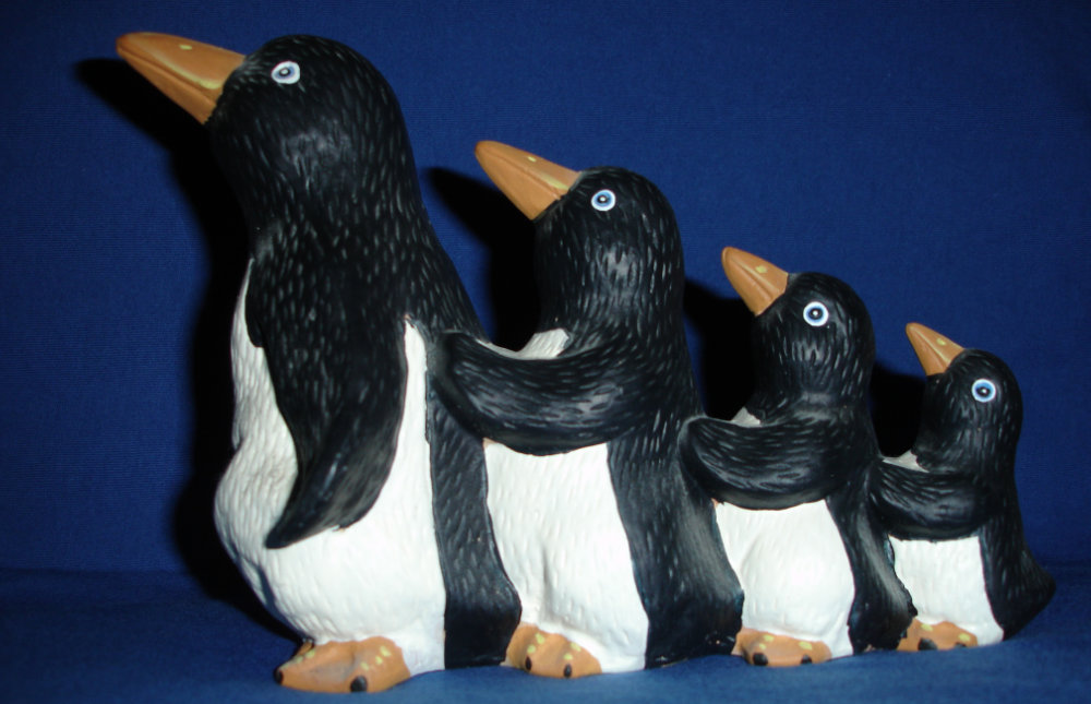 Vier Pinguinfiguren, die eine Polonaise machen.